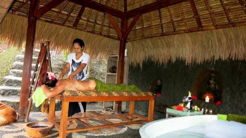 Traditional Balinese massage in an open-air bale in Bali, with candles, frangipani flowers and a flower petal bath